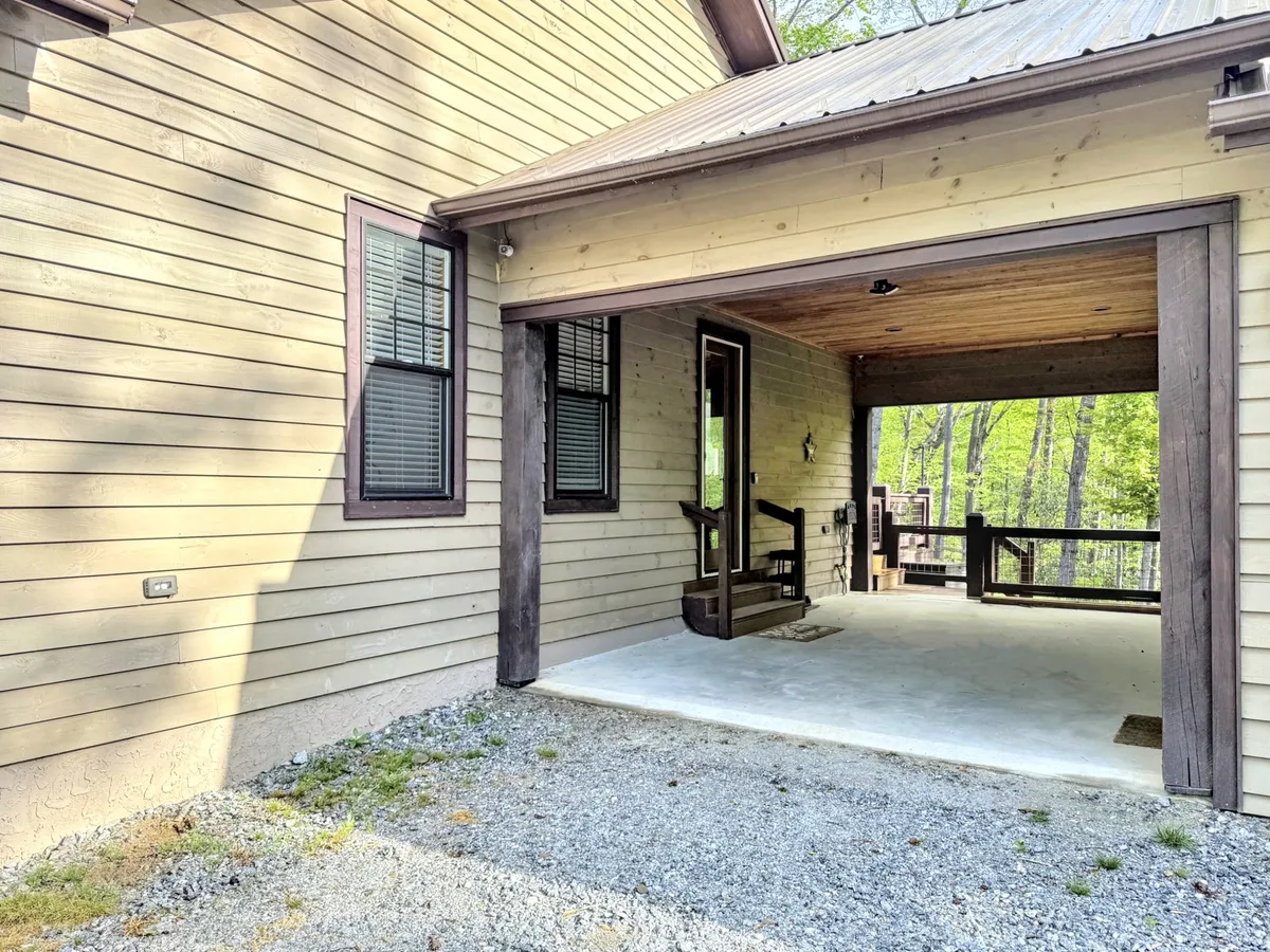 A covered entrance framed with wooden posts and a gravel pathway, offering a cozy, inviting transition from outdoor adventure to the serenity of home. The porch hint at shared moments and anticipation of coming home after a day out.